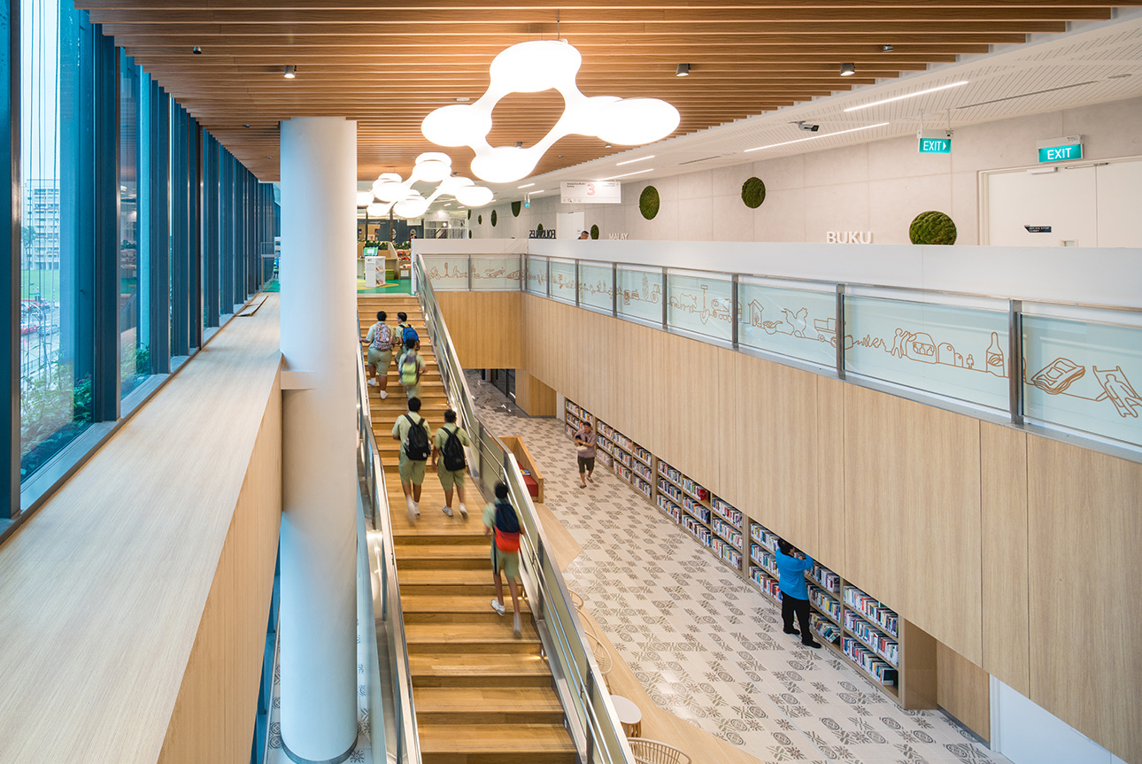 Schoolchildren walking the timber stairs inside Tampines Library at Our Tampines Hub